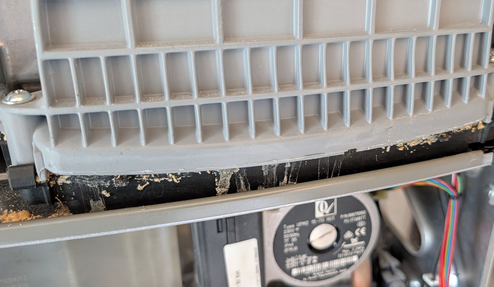 Condensate residue along a worn flue manifold gasket inside a boiler